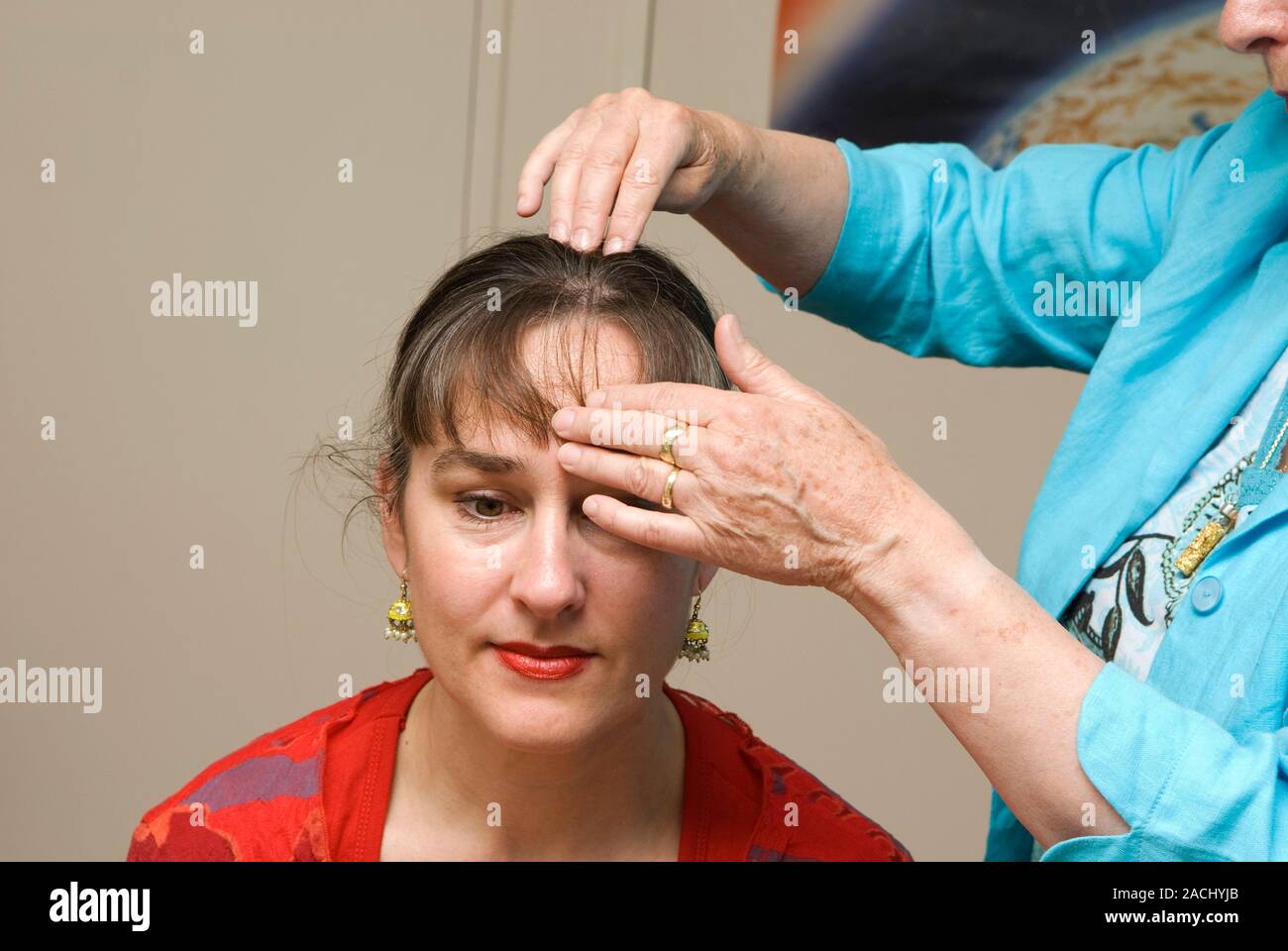 Metamorphic massage. Therapist working on a patient's head using