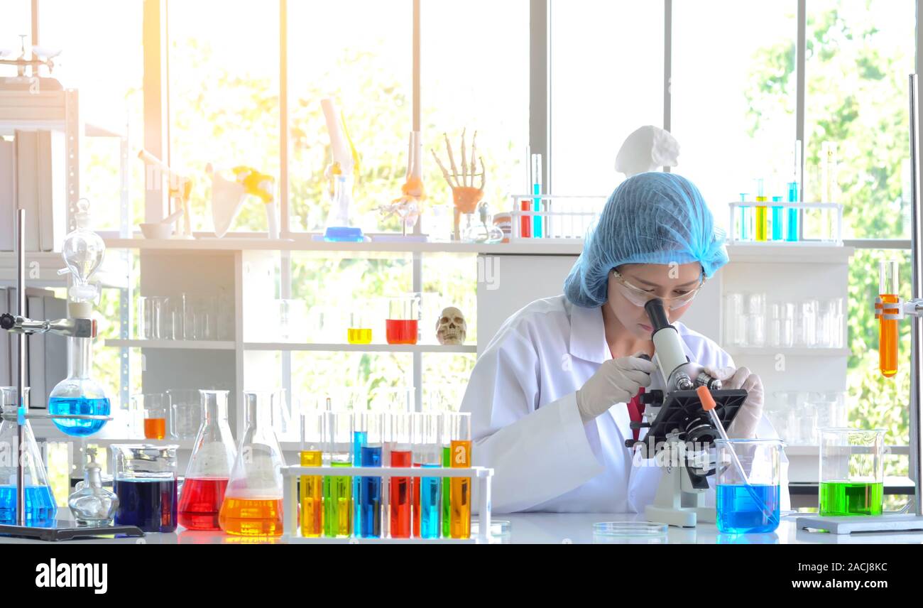 The woman scientist doing experiment using microscope in laboratory
