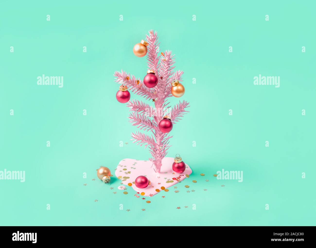 Pink Christmas tree decorated with red and golden balls. Modern greeting card. Minimal holiday