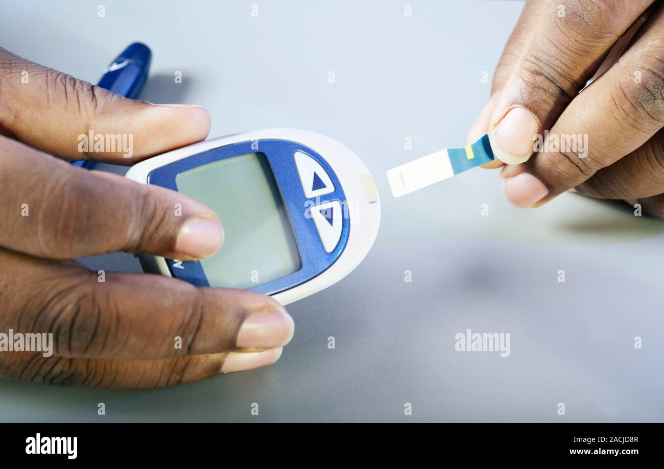 Blood glucose test. Glucometer being used to test a diabetic's blood ...