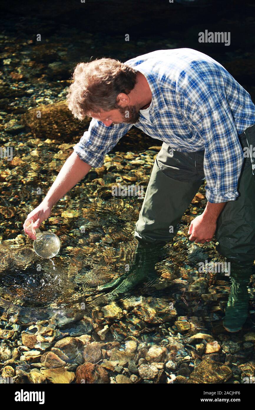 Biologist collecting a water sample during field work Stock Photo Alamy