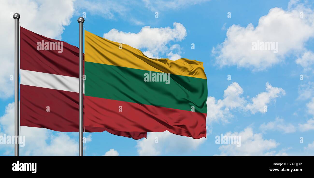 Latvia and Lithuania flag waving in the wind against white cloudy blue sky together. Diplomacy concept, international relations. Stock Photo