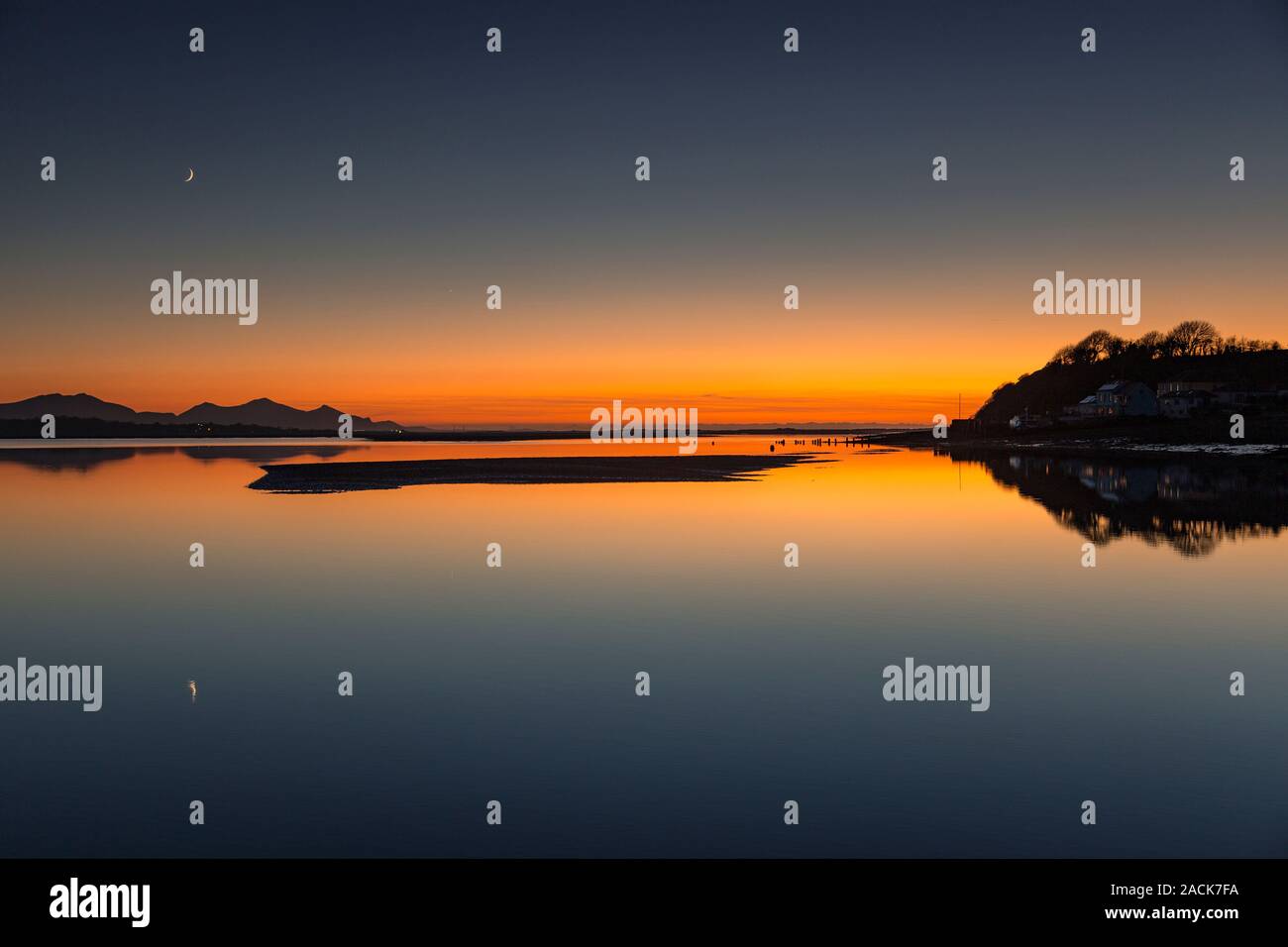 Dusk and moonset over the Menai Straits, Anglesey, North Wales Stock Photo