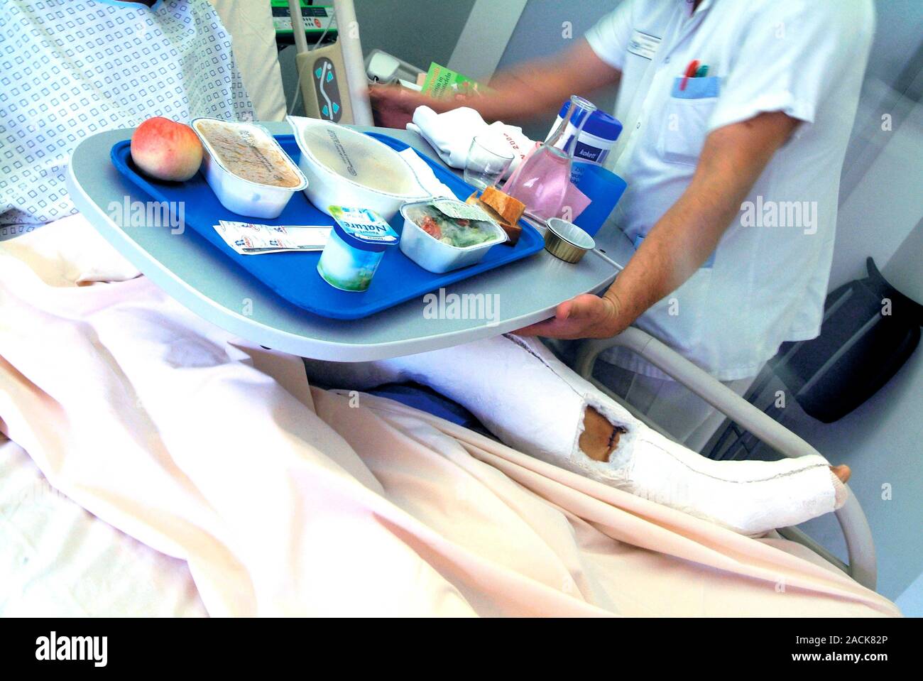 Hospital meals. Hospital worker serving food to a patient on a ward