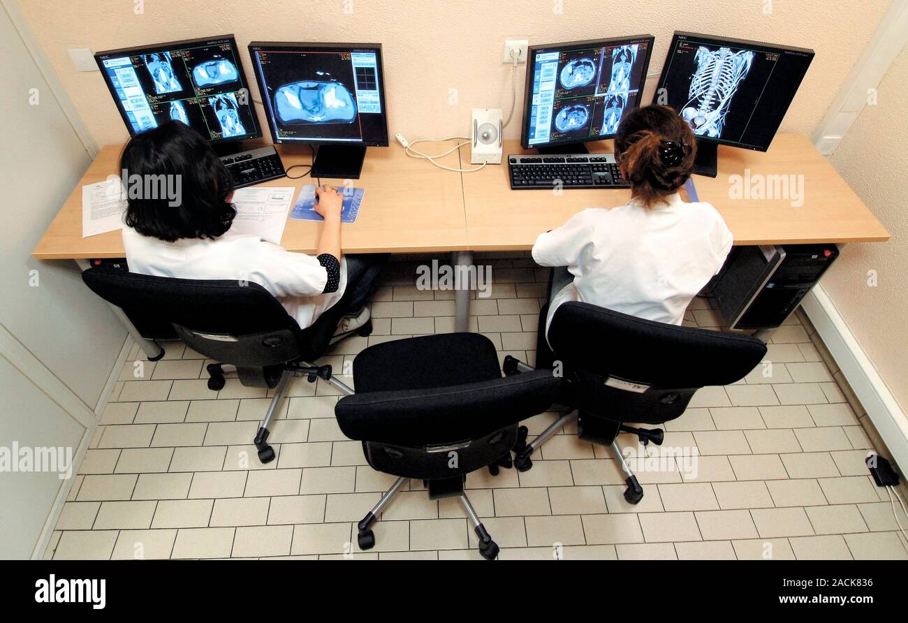 Radiology training. Radiology students examining MRI resonance imaging) scans