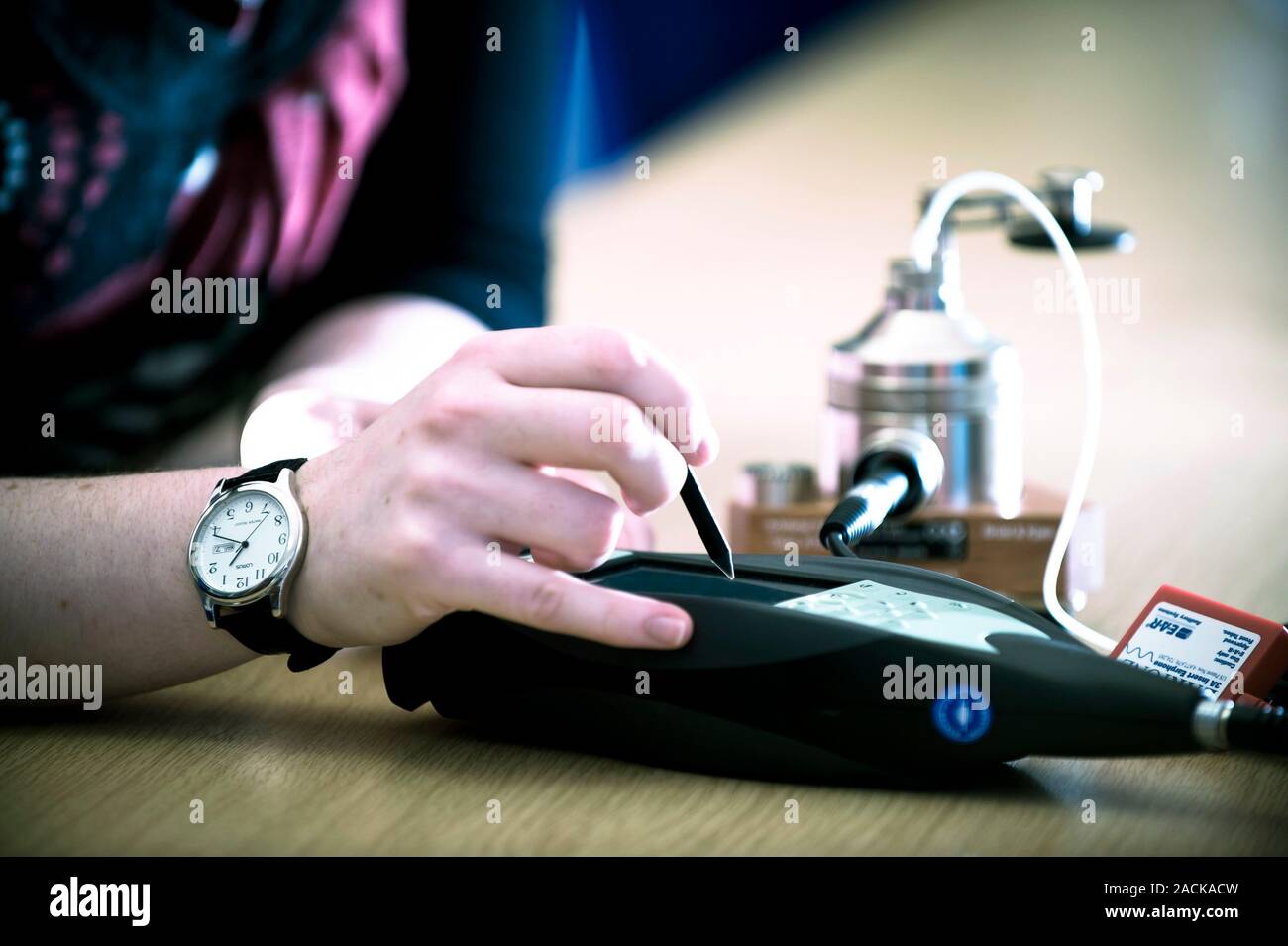 Calibrating an audiometer. Audiology student using an artificial ear