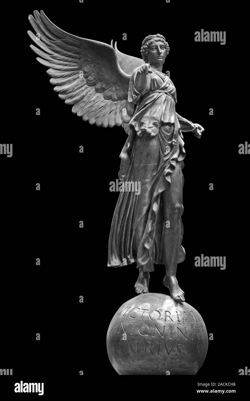 Bronze statue of a Winged Victory. Frontal view of a Statue of the goddess Nike, isolated on black background by clipping path. Stock Photo