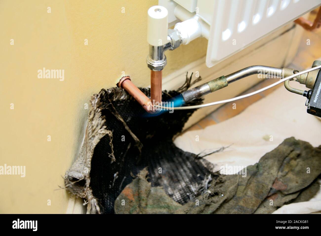 Radiator leak being repaired. Welding torch and solder being used to