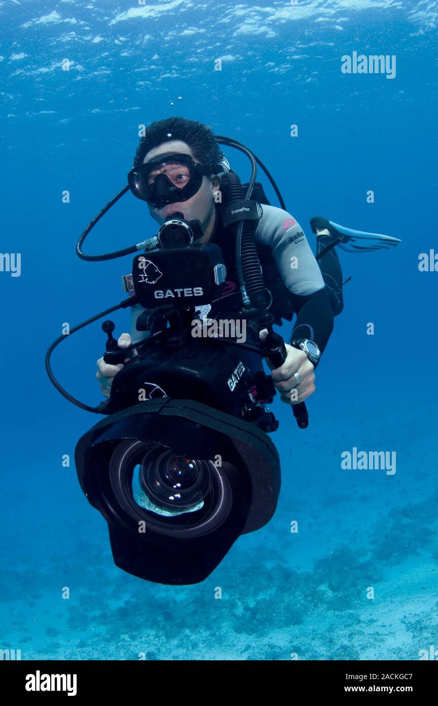 Underwater cameraman using scuba diving equipment while filming on a
