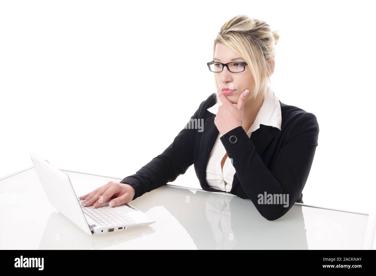 Young Businesswoman on laptop ponders Stock Photo