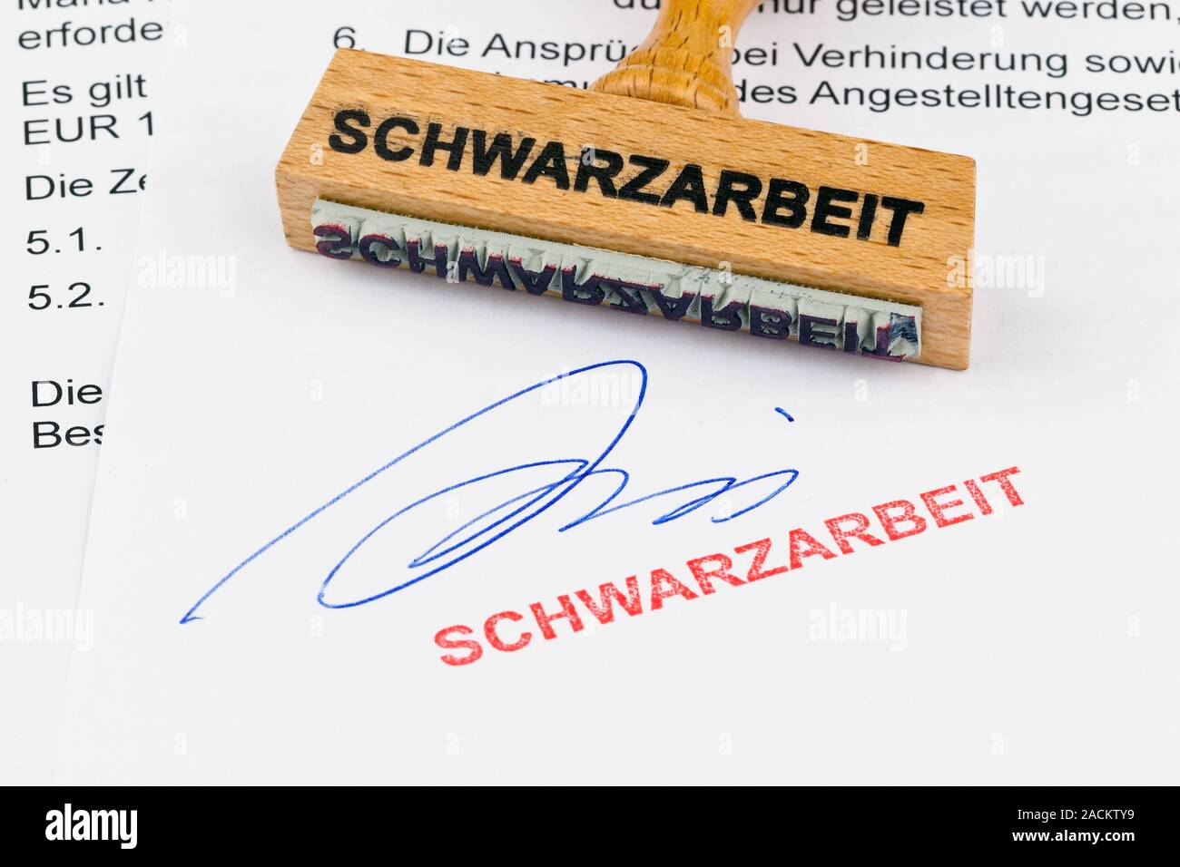 Wooden stamp on document: Schwarzarbeit Stock Photo