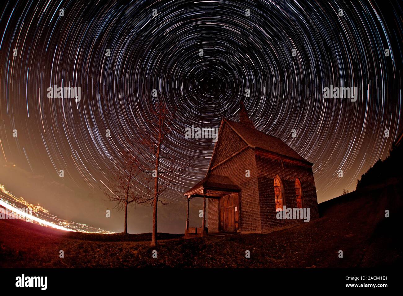Star trails over an alpine church. Time-exposure image of star trails ...