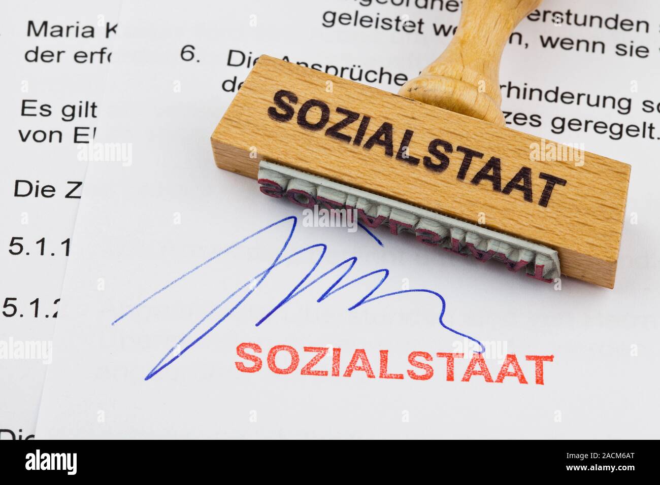 Wood stamp on document: welfare state Stock Photo