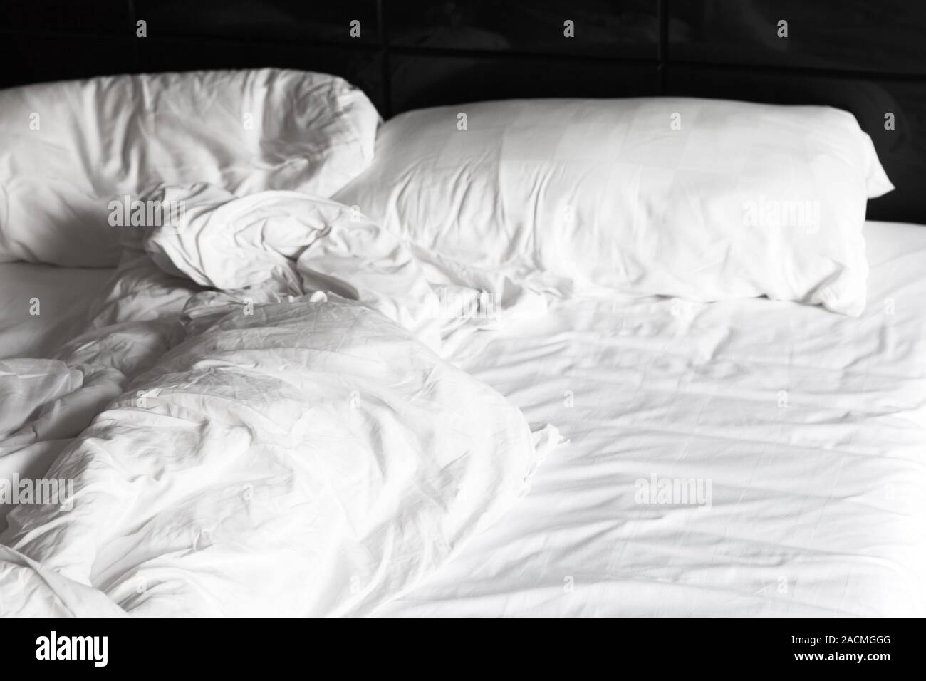 Crumpled blanket and pillows lay at an empty bed, sleeping time