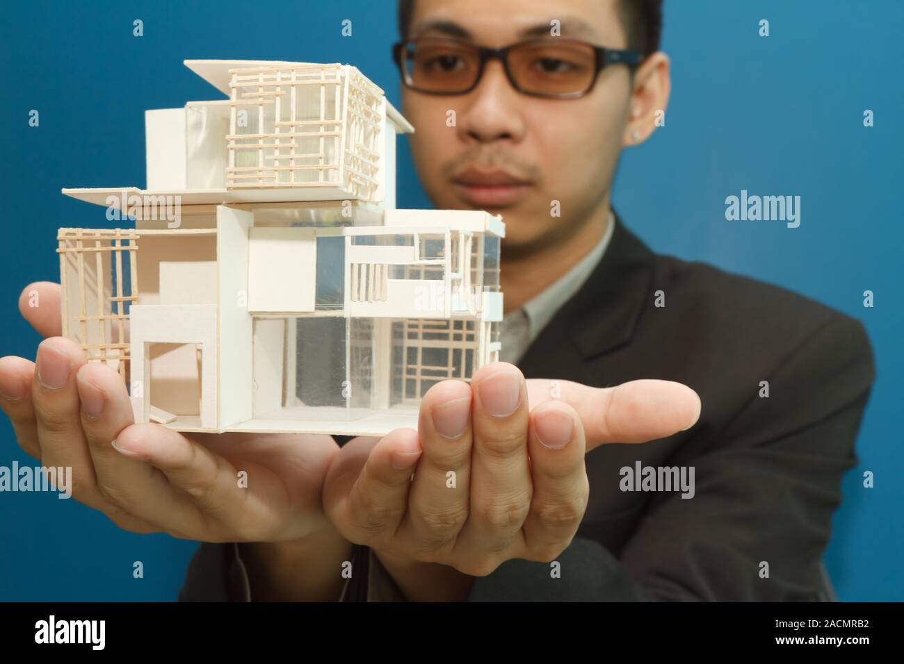 Man holding a model of a house in his hands Stock Photo - Alamy