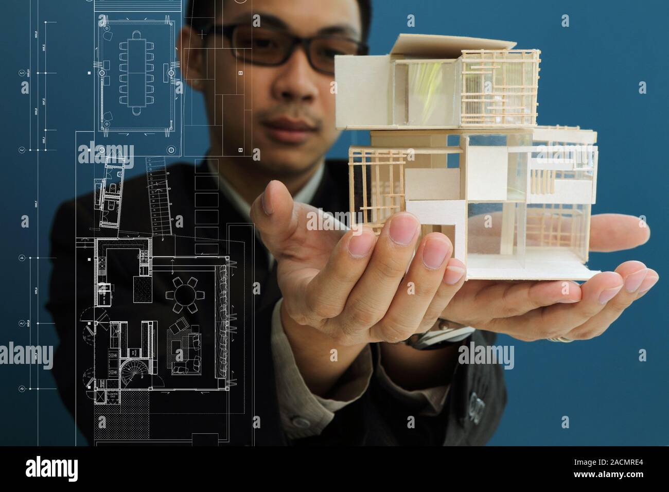 Man holding a model of a house in his hands Stock Photo - Alamy