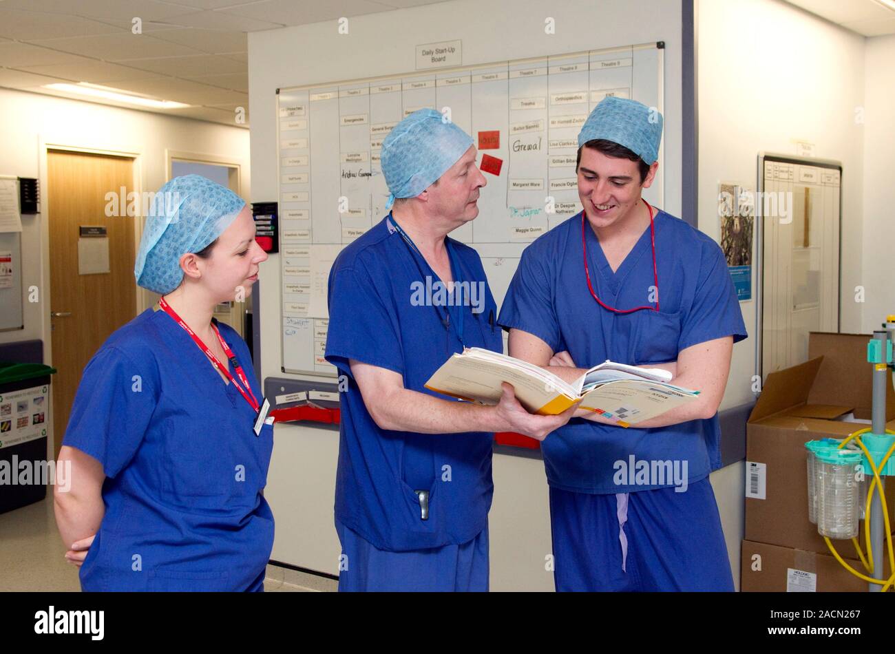 Surgeons discussing patient notes on a hospital ward Stock Photo