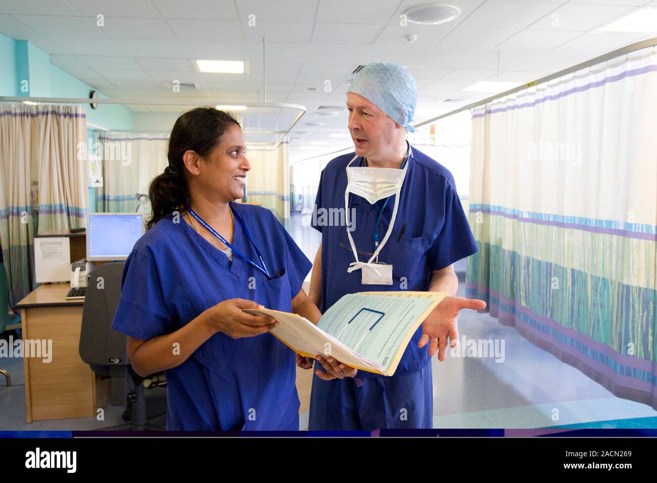 Surgeons discussing patient notes on a hospital ward Stock Photo