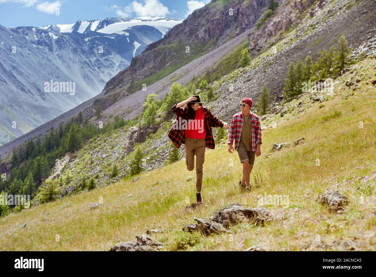 Happy couple of young hipsters are walking in mountains Stock Photo