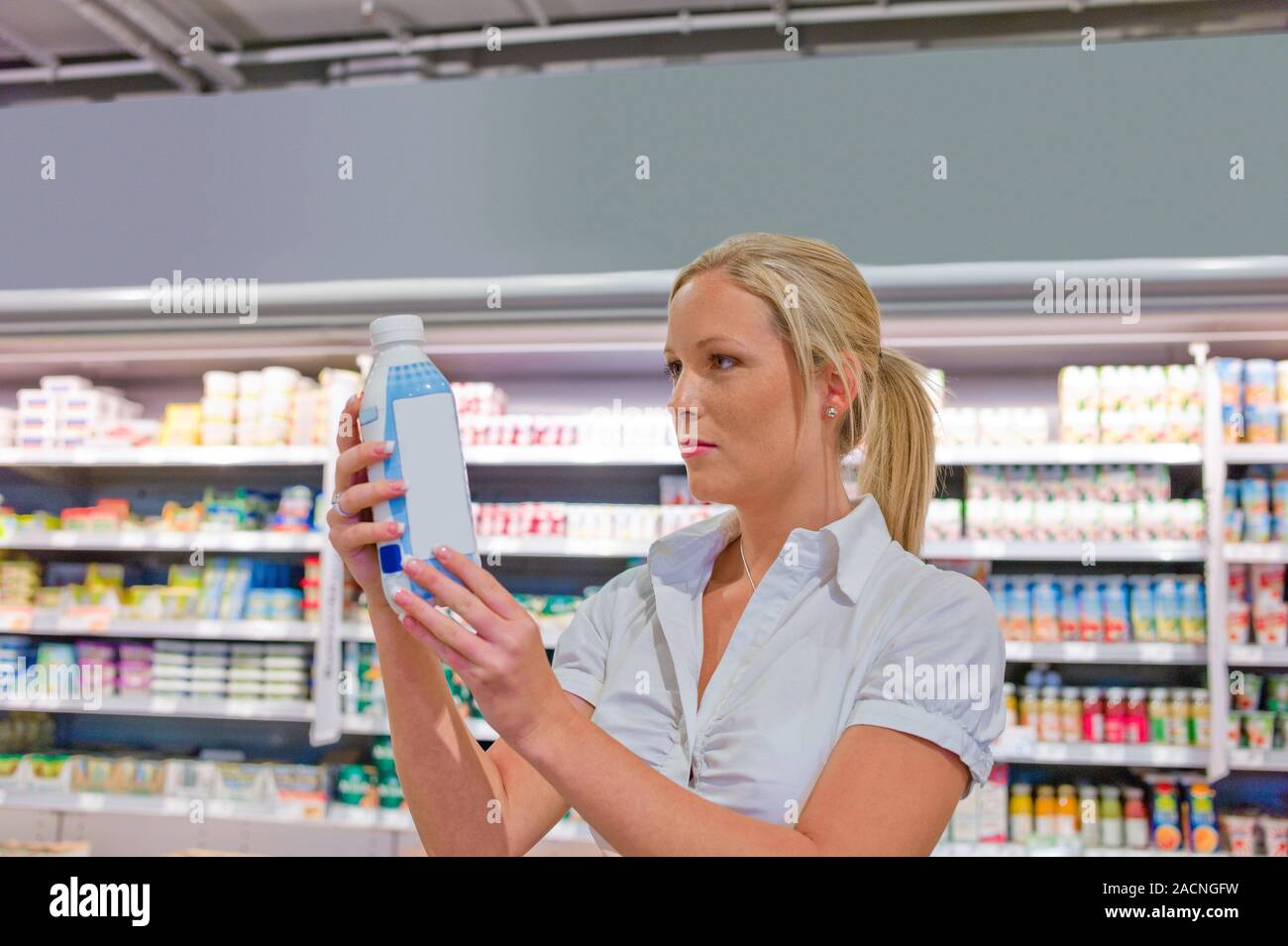 Woman buys milk in supermarket Stock Photo - Alamy