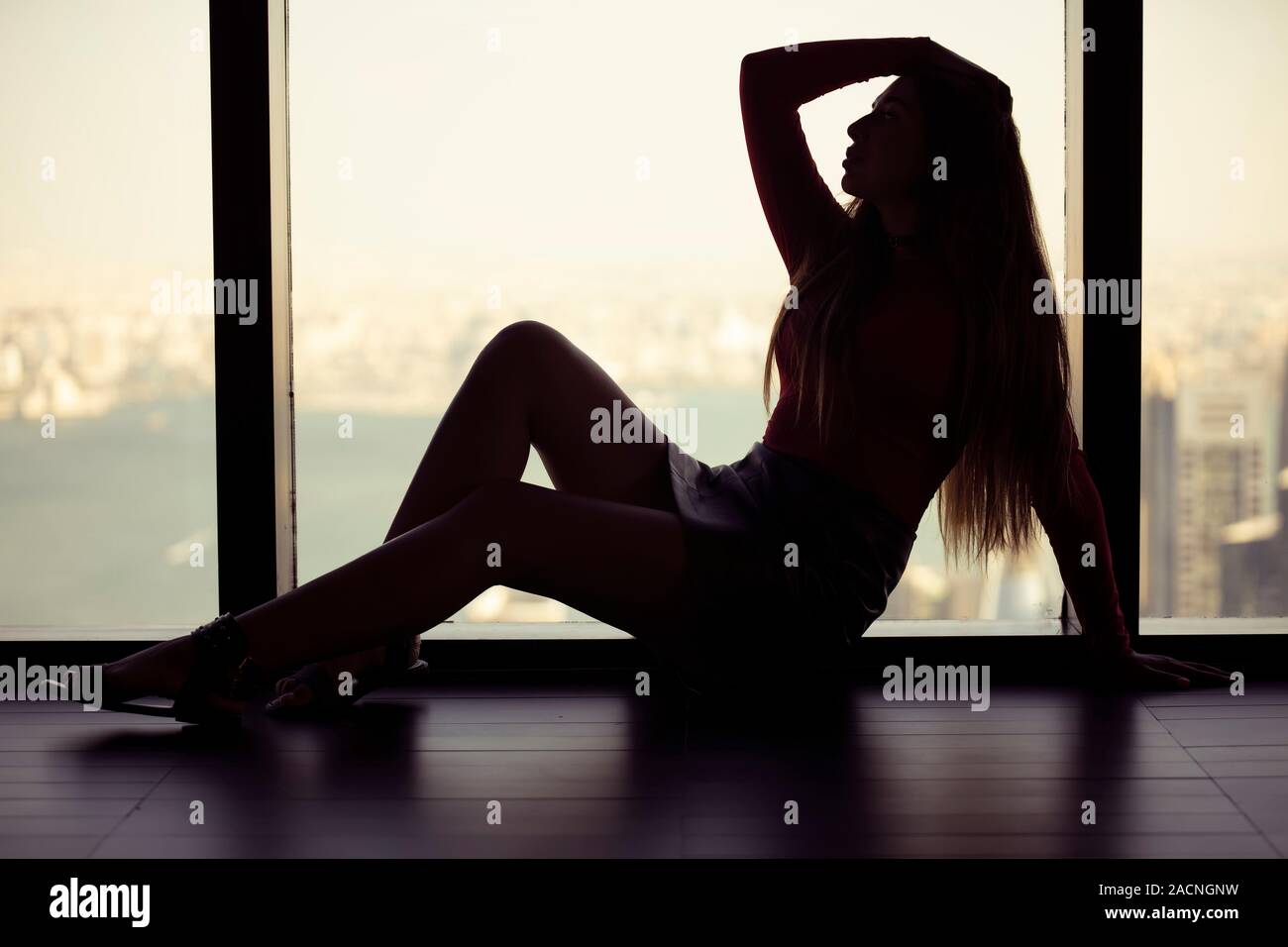 A Silhouette Girl  sitting on floor Stock Photo
