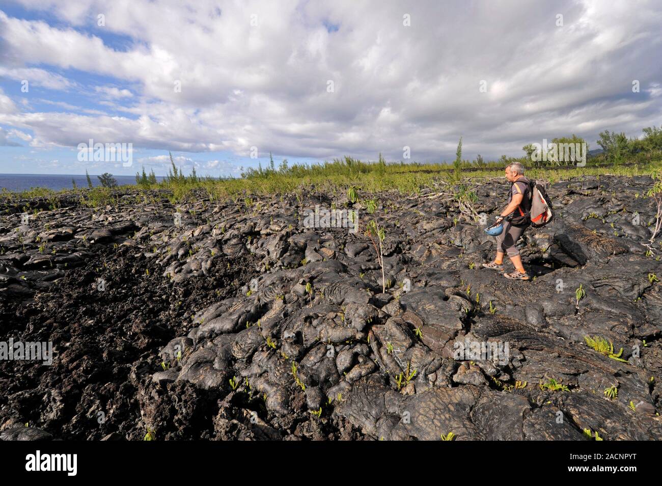 Lava cave exploration. Cave guide standing on ancient solidified lava
