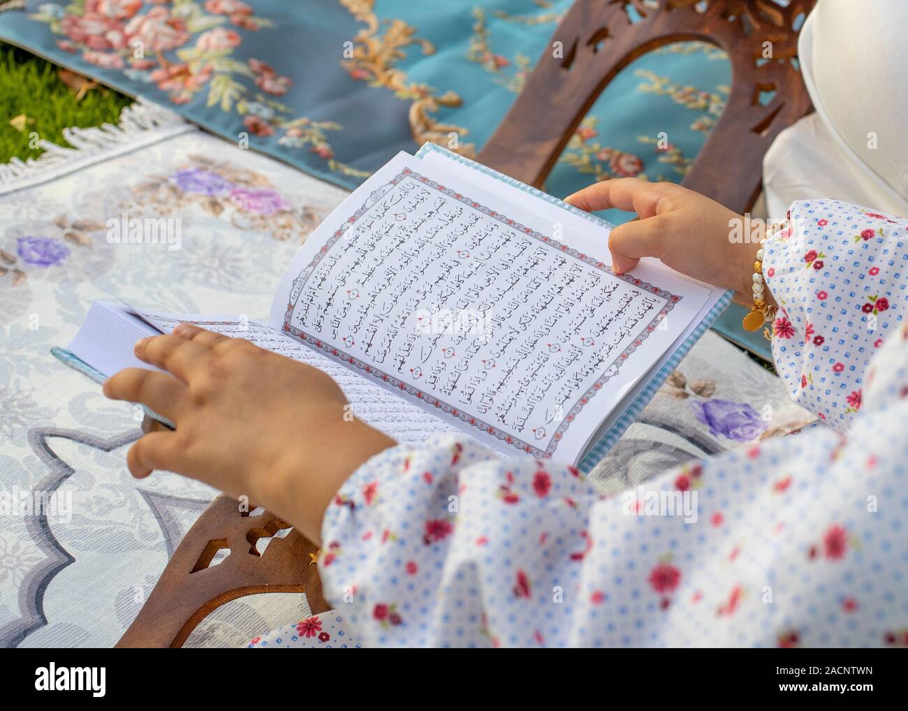 A Muslim Girl reading quran Stock Photo