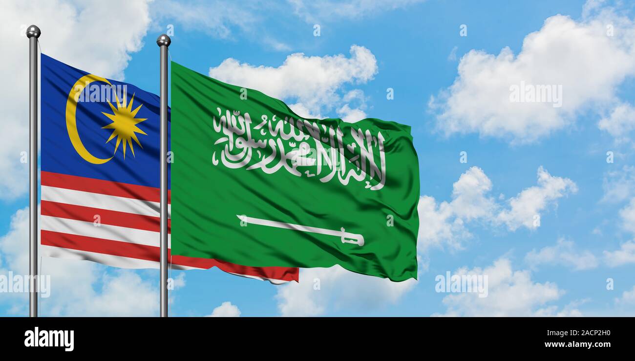 Malaysia and Saudi Arabia flag waving in the wind against white cloudy blue sky together. Diplomacy concept, international relations. Stock Photo