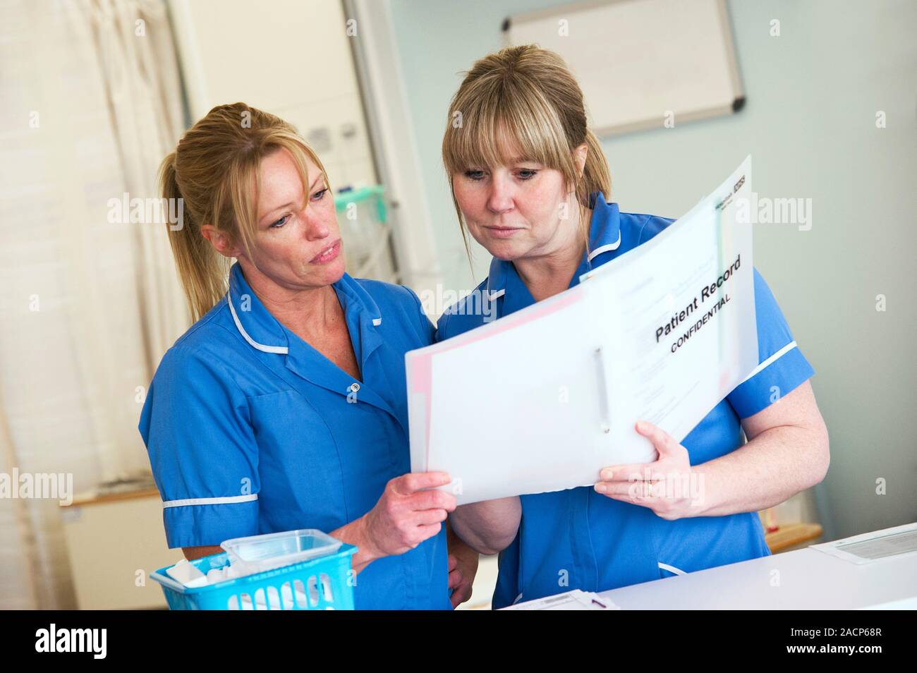 Nurses discussing patient records on a ward. Stock Photo