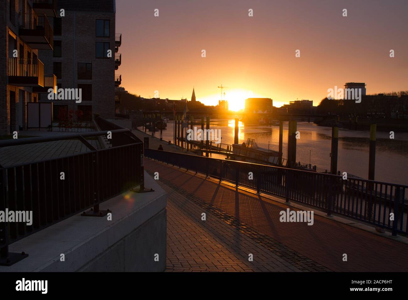 Sunrise at the Weser in Bremen with modern residential buildings in the foreground and a construction site of an office building in the background Stock Photo