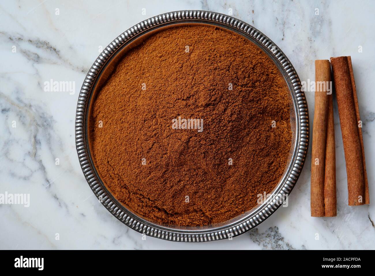 Chinese cassia (Cinnamomum cassia), cinnamon sticks and ground cinnamon in a bowl, India Stock