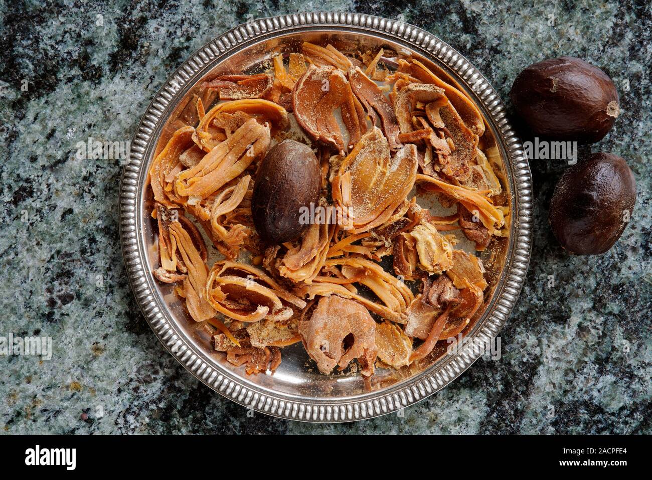 Nutmegs (Myristica fragrans) and mace, macis, in bowl, India Stock Photo