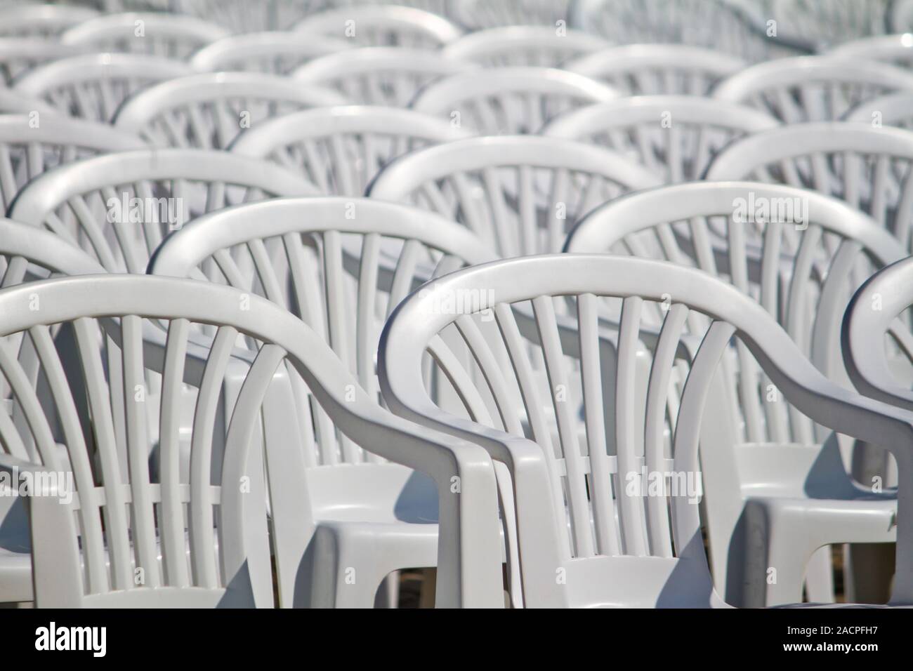 aligned white plastic chairs Stock Photo Alamy