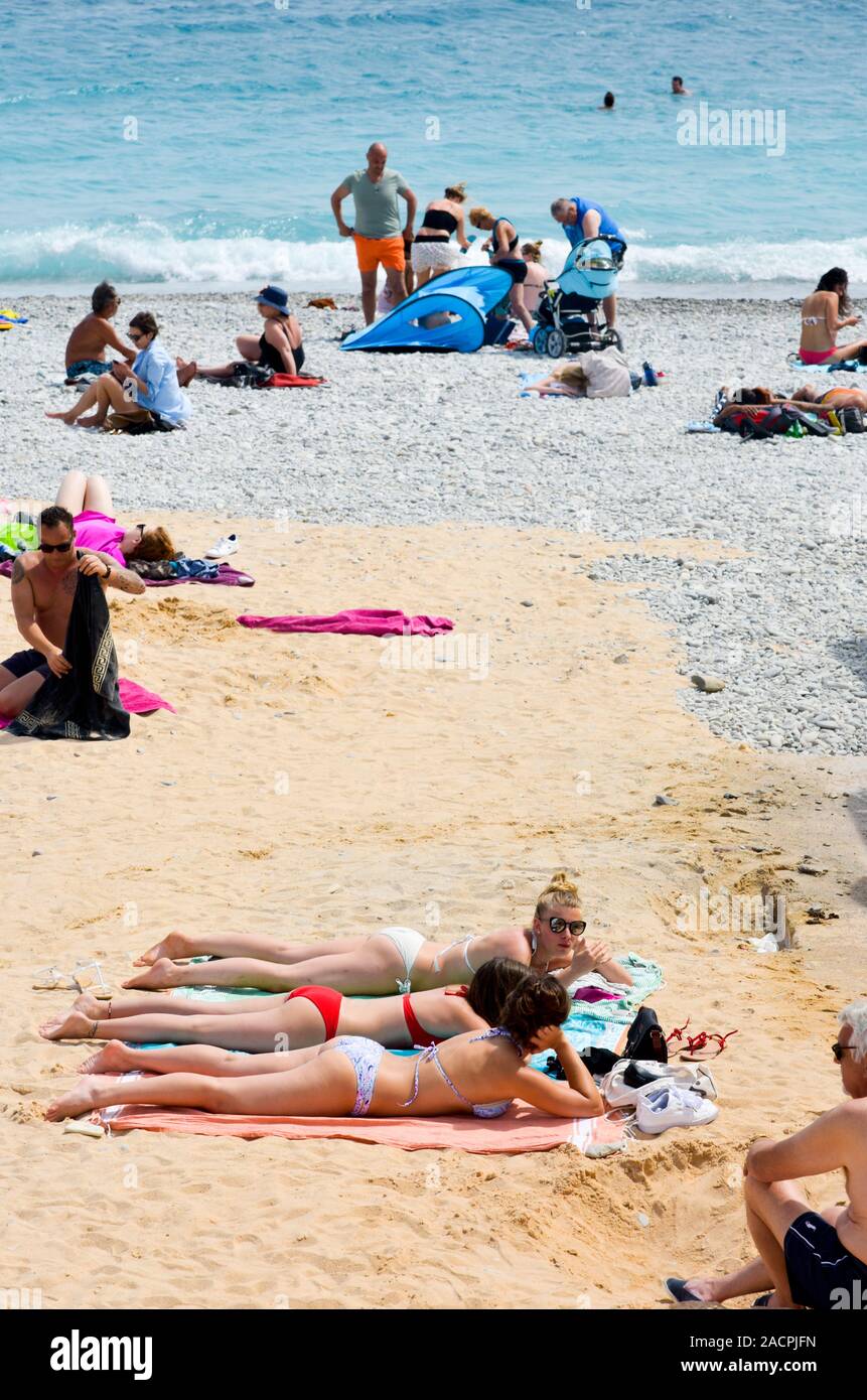 NICE, FRANCE - JUNE 4, 2017: People sunbathing on the beach in Nice, in the French Riviera, France, next to the Promenade des Anglais, the famous seaf Stock Photo