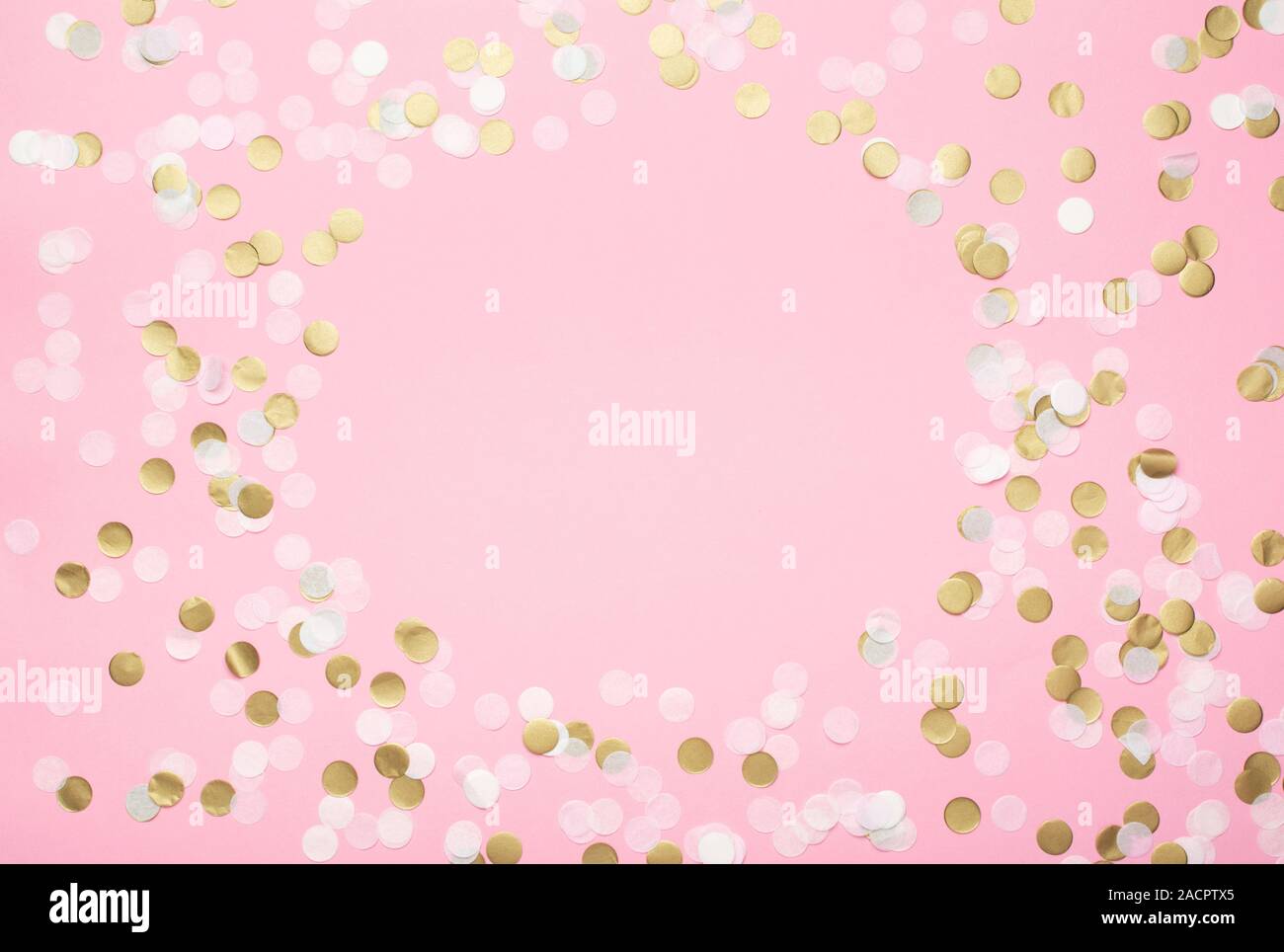 Paper confetti in pale pink, white and golden on pastel pink background, top view, selective Stock Photo