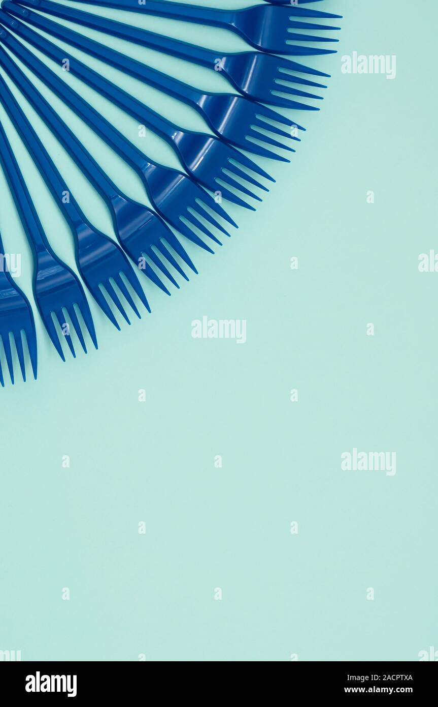 Blue plastic forks on a blue background, vertical orientation, copy space, place for text Stock Photo