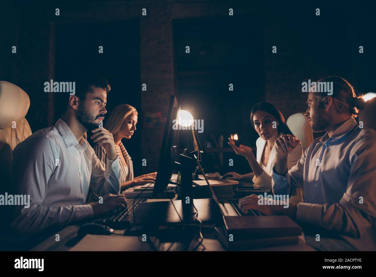 Profile side view of nice attractive skilled experienced hardworking intellectual coworkers sharks experts financier ceo boss chief working at night Stock Photo