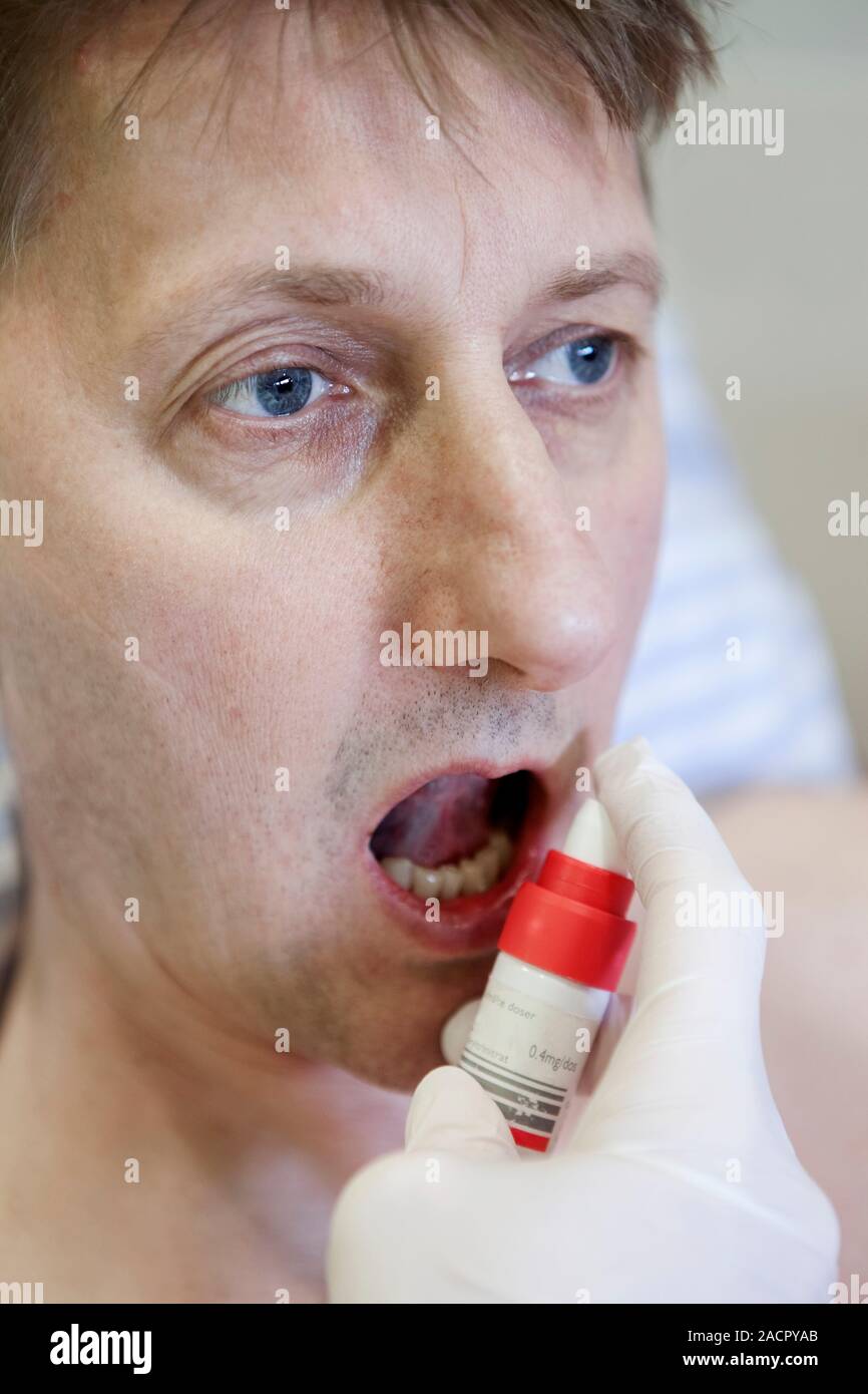 Cardiac patient in an ambulance. Paramedic administering a glyceryl