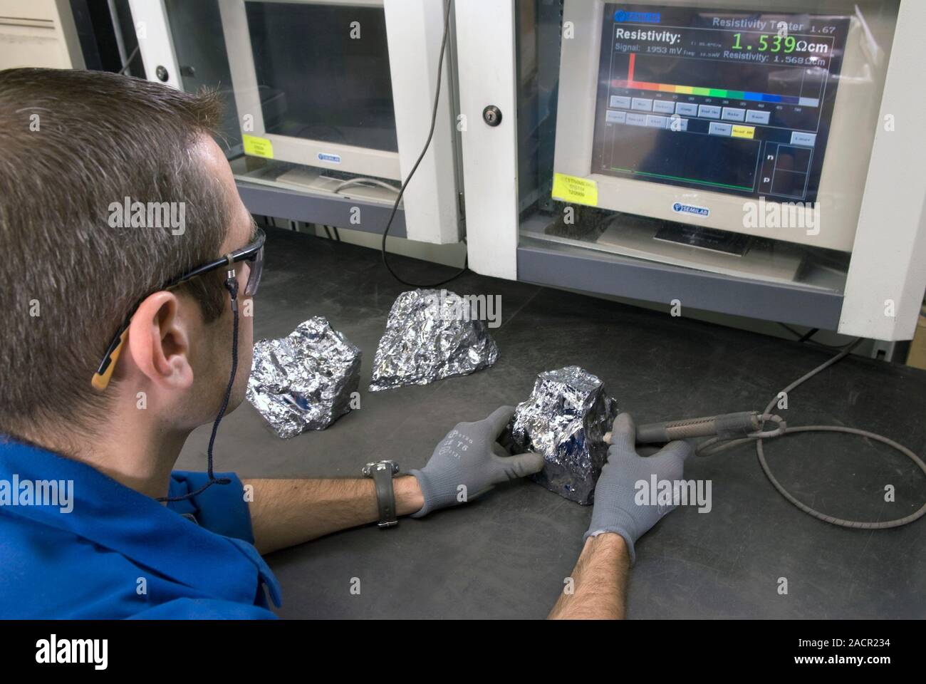Manufacturing solar panels. Worker testing the conductivity of blocks