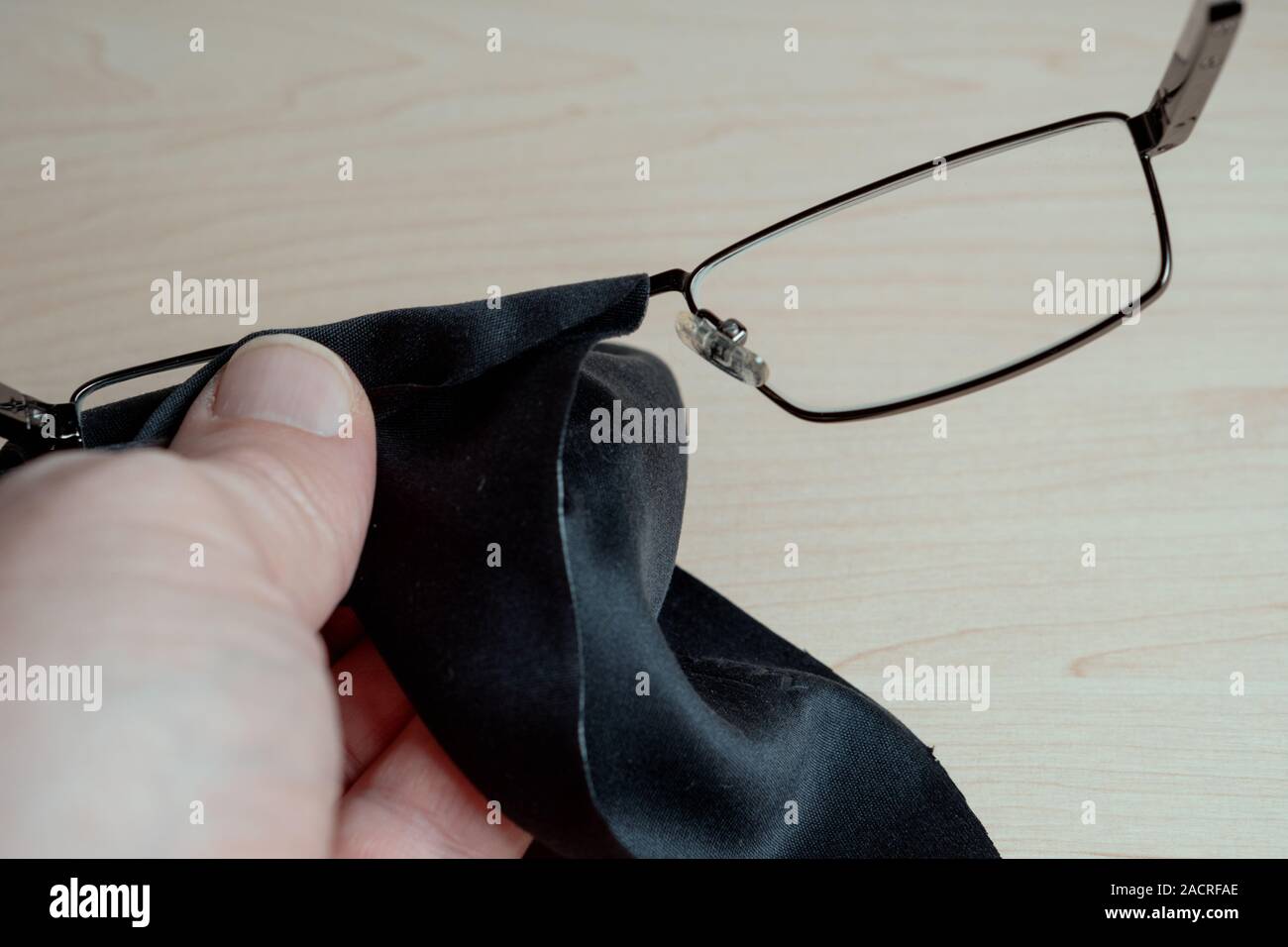 Cleaning glasses. A man wipes his glasses with a cloth. Storage and