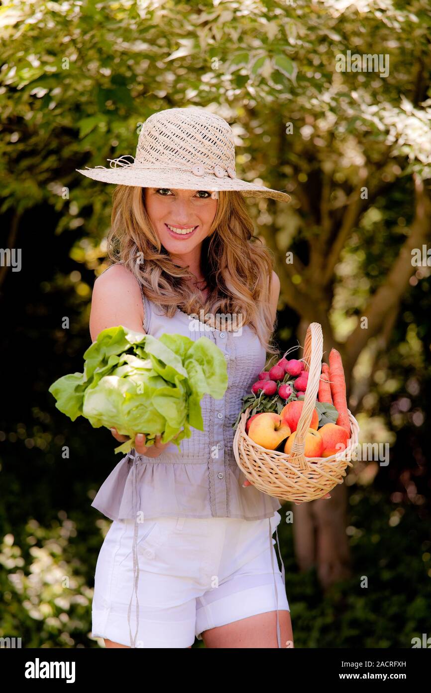 Fruit and vegetables in a basket with a woman Stock Photo - Alamy