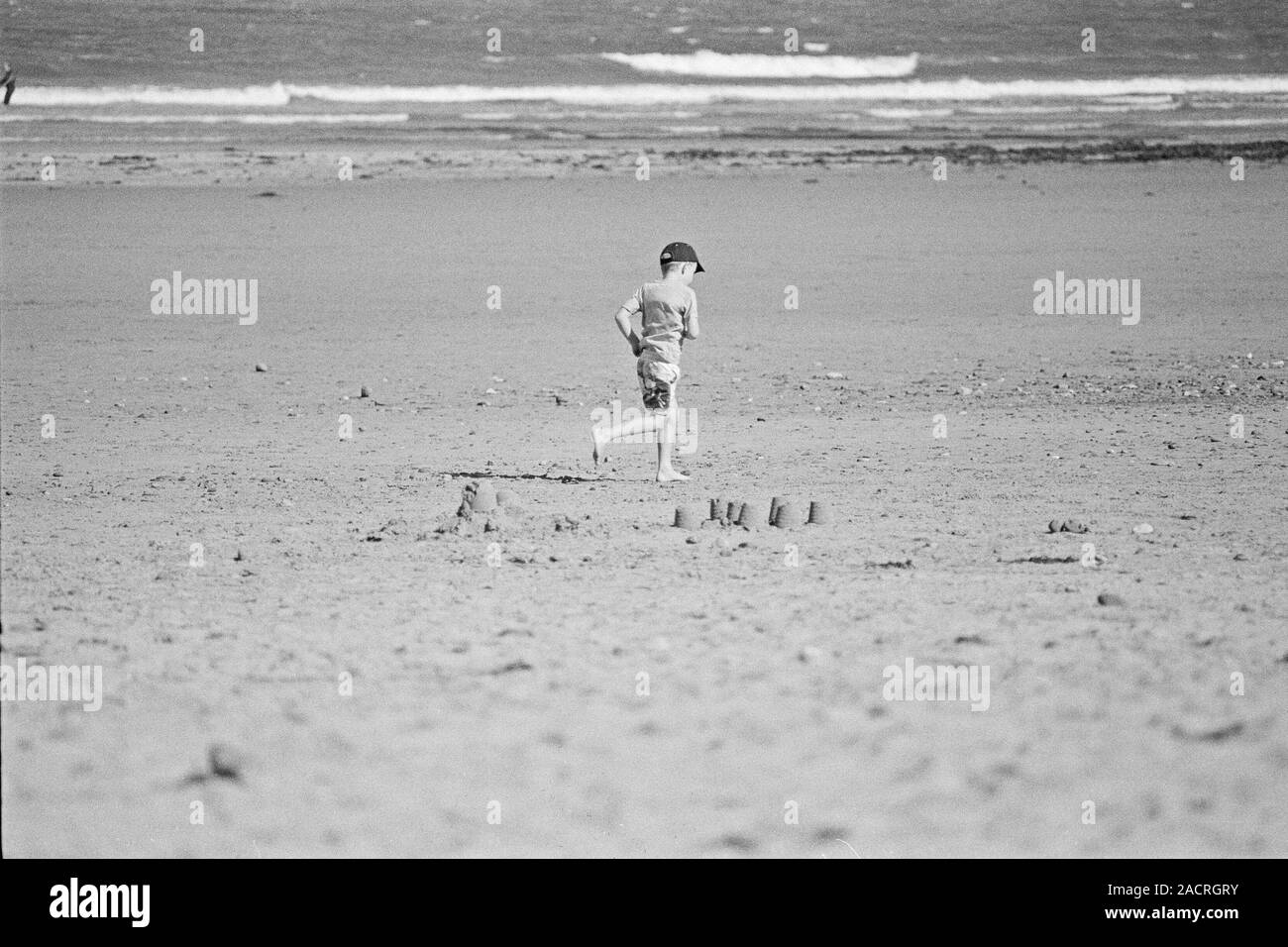 Boy running on sandy beach, Saltburn - United Kingdom Stock Photo