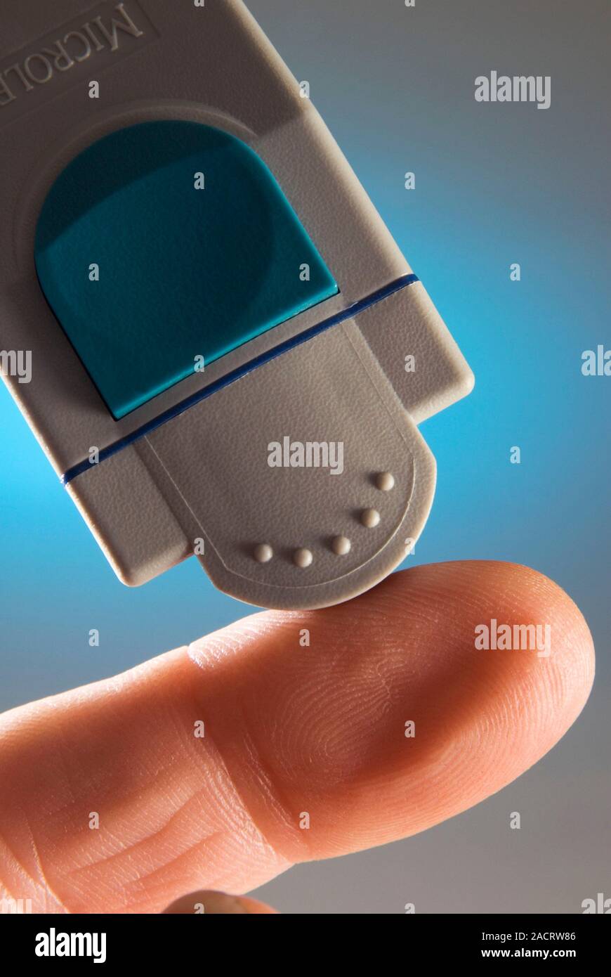 Blood glucose test. Diabetic lancing their finger to test their blood