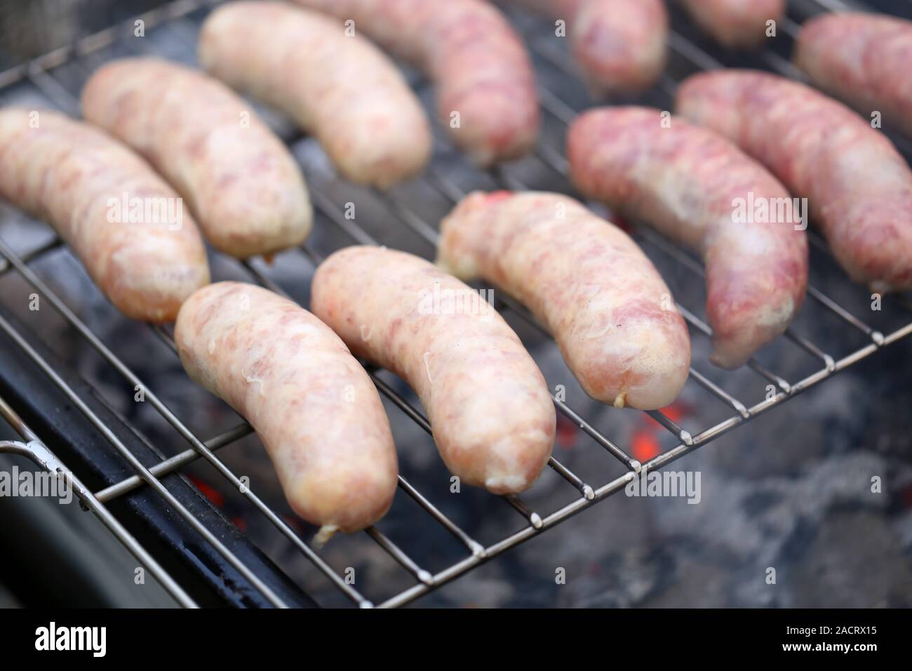 Fresh sausage grilling on a barbecue grill. Stock Photo