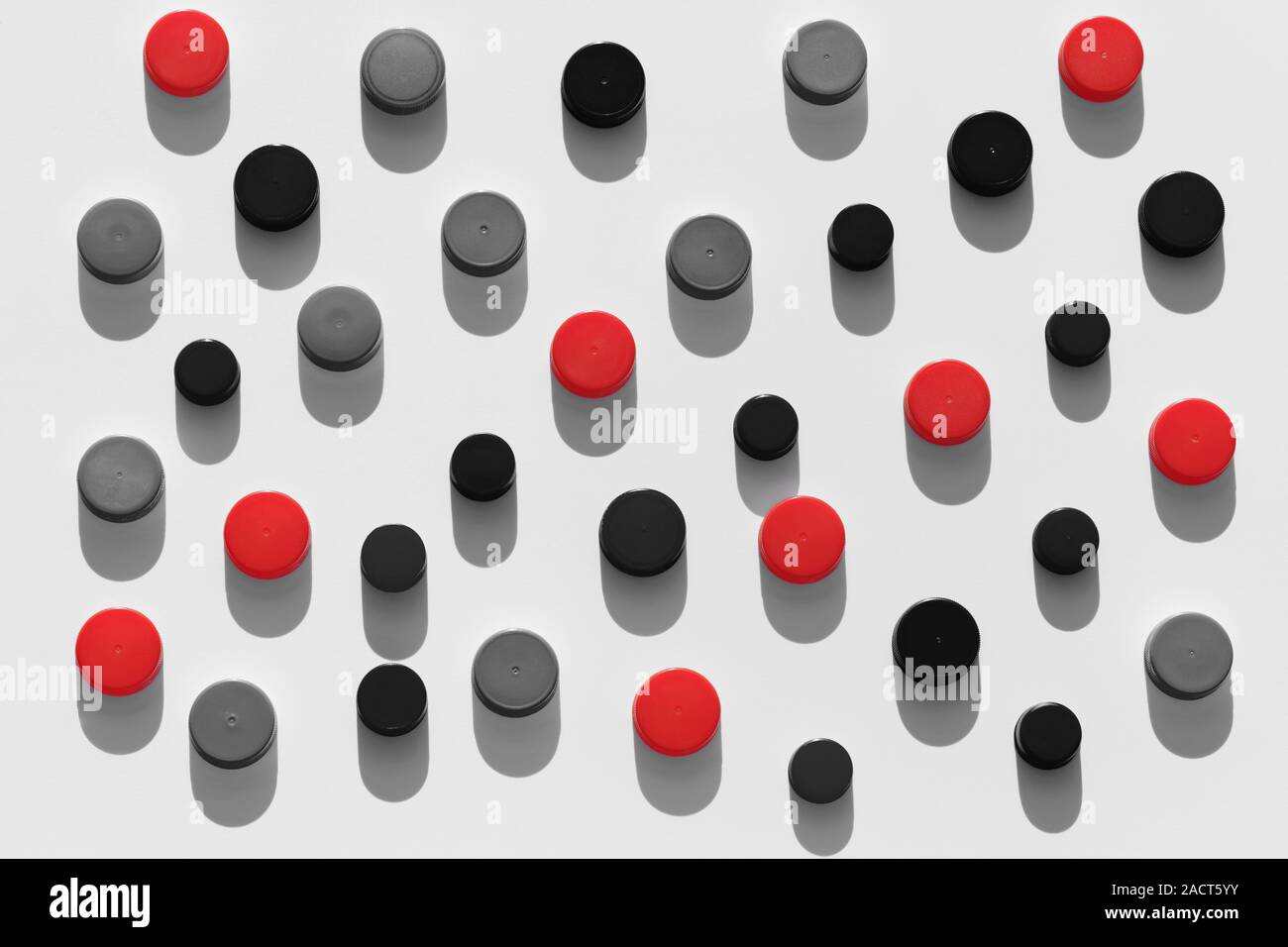 Plastic bottle caps background with black and red color random pattern on white background Stock Photo