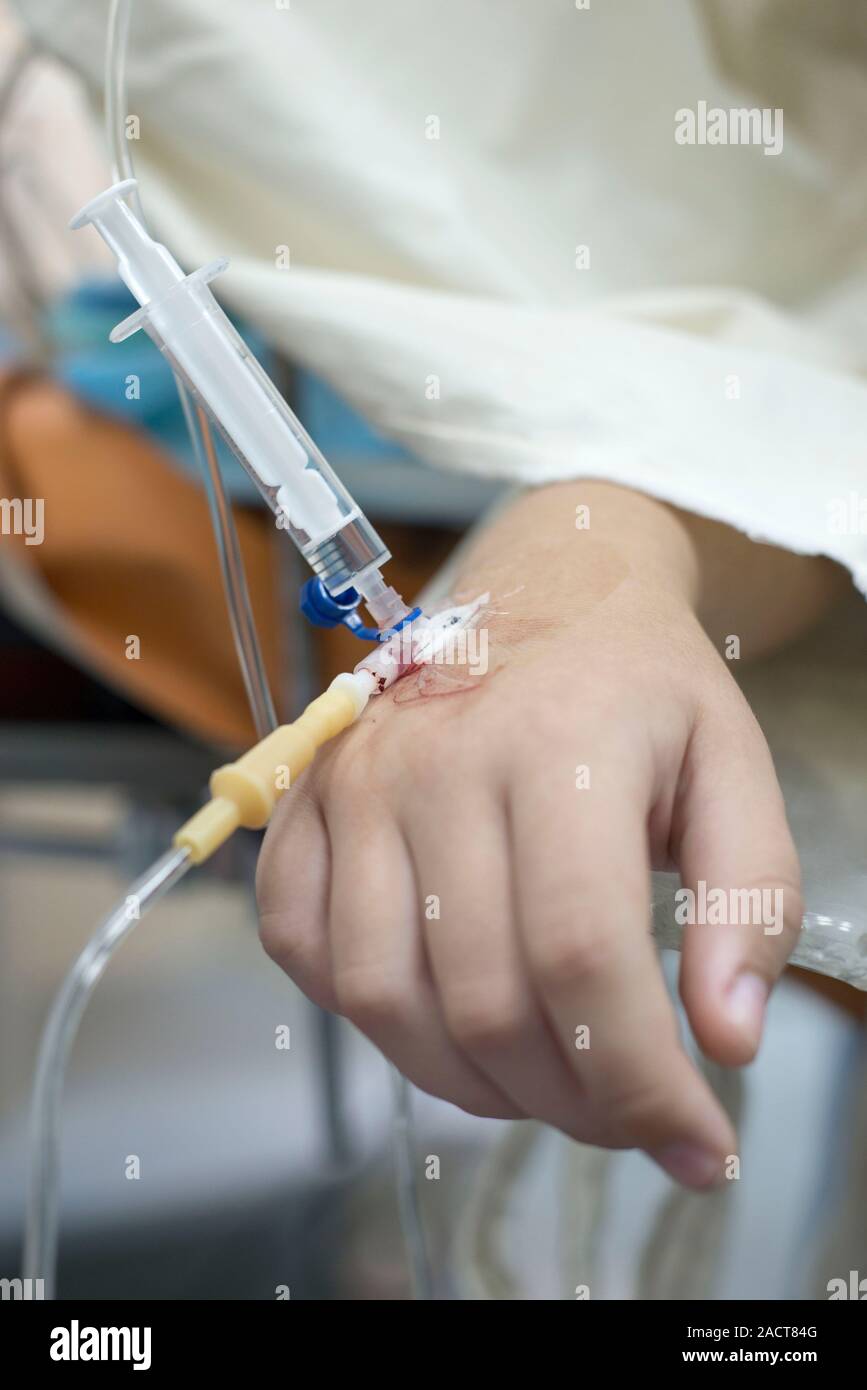 intravenous injection to the child. Hand of a child with a needle. Intravenous infusion system. Sick children in the hospital. Stock Photo