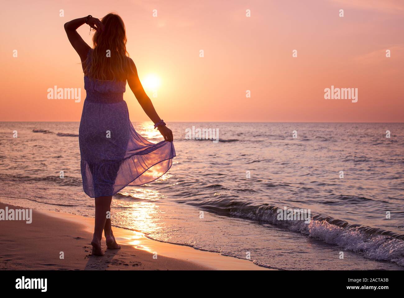 Happy Carefree Woman In The Blue Dress Enjoying Beautiful Sunset On The Beach Lady S Silhouette Against Colorful Calm Sunset Beach Stock Photo Alamy