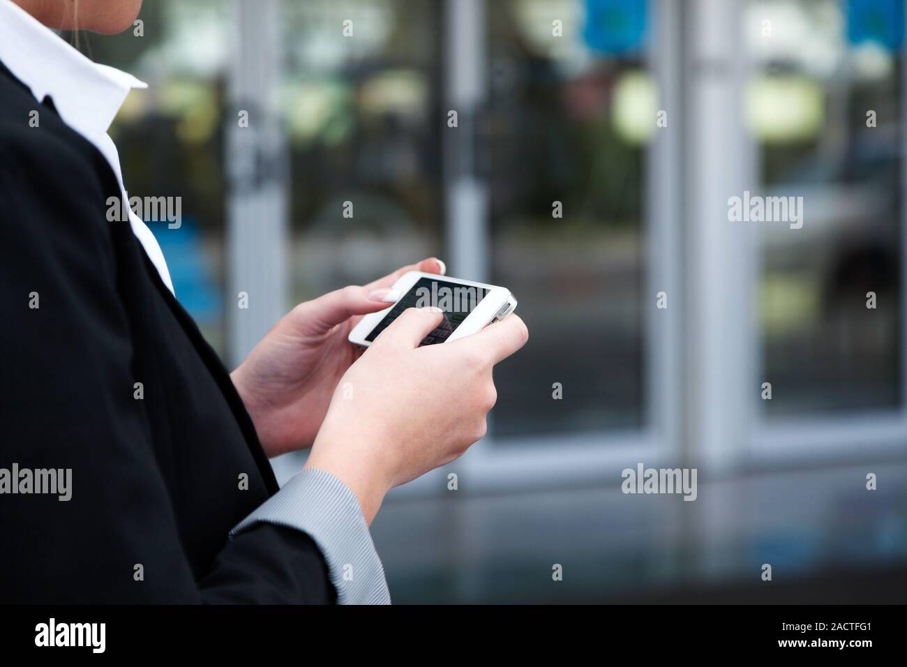 Woman writes an SMS with her mobile phone Stock Photo
