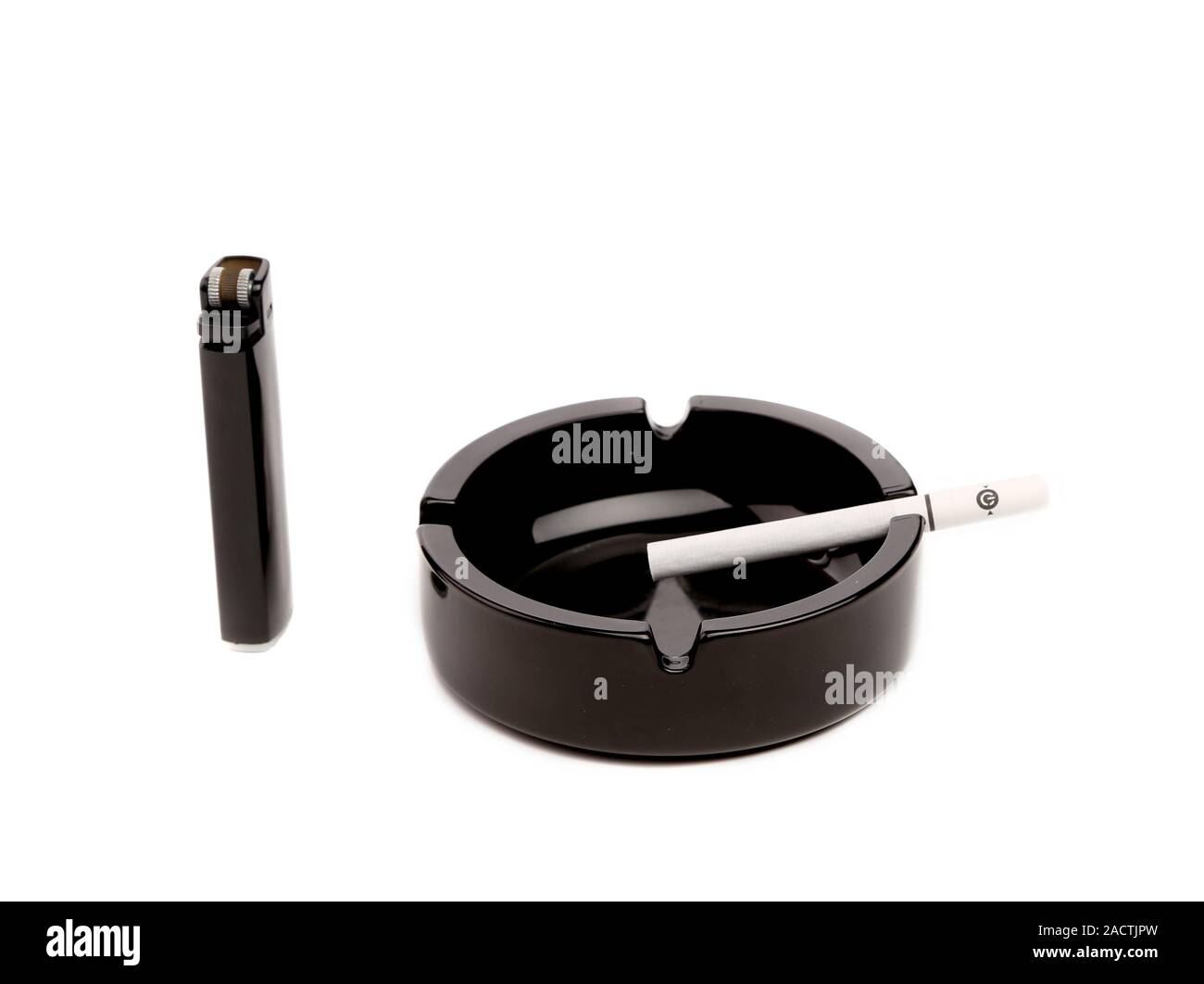 Black ceramic ashtray with cigarette and lighter. Stock Photo