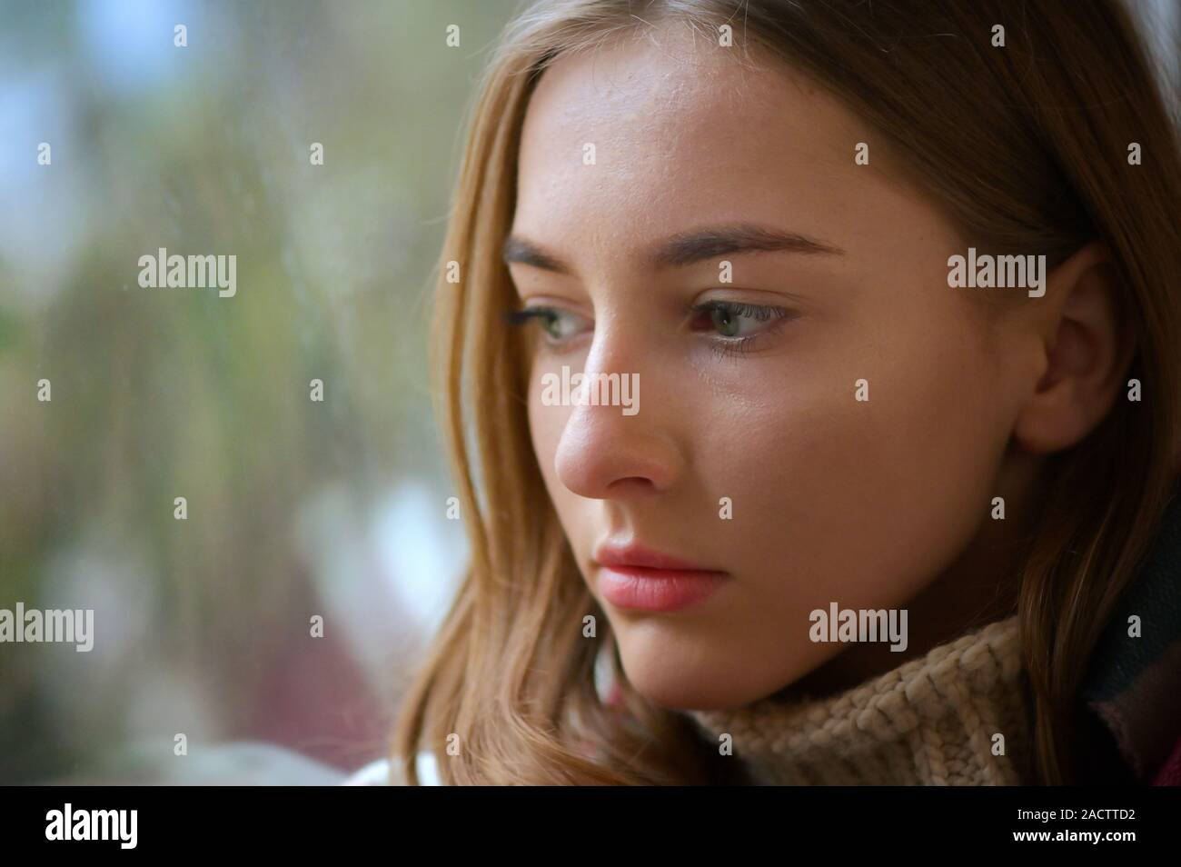 Young Woman Sitting By The Window Stock Photo